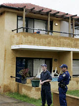 Police stand outside a western Sydney apartment block that was raided by police in the early hours of Tuesday, Nov. 8, 2005. (AP /Mark Baker)